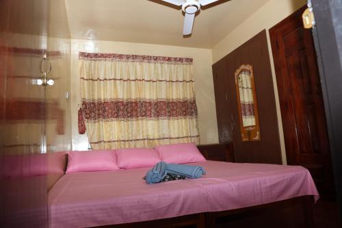 a pink couch in a room with a window at Baski Guest House in Jaffna