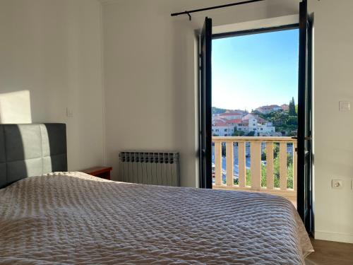 a bedroom with a bed and a view of a balcony at City Center Suites - Apartment with Terrace and Private Pool in Cavtat