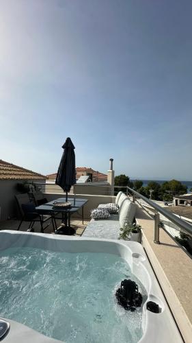 a jacuzzi tub on a balcony with a table at Marilena Mare Seaside & Jacuzzi House 50meters from sea in Ialyssos