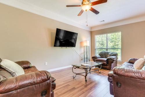 a living room with leather furniture and a flat screen tv at 11 Mi to Dtwn Little Rock Home with Large Deck! in Mabelvale