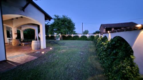 a backyard of a house with a grass yard at Casa Caginia 300mqgiardinopalestra e biliardo in Tigliole