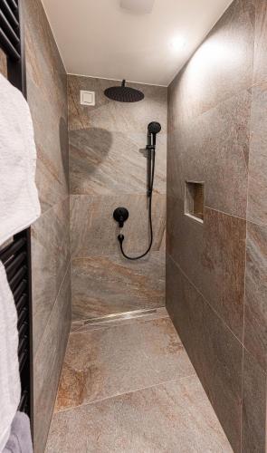 a shower in a bathroom with a stone wall at Apartment Pica in Bad Elster
