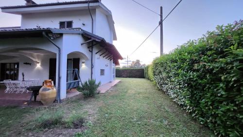 a white house with a garden and a table at Casa Caginia 300mqgiardinopalestra e biliardo in Tigliole