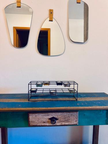 a blue table with two mirrors on a wall at Gutshaus Haidhof in Gingst