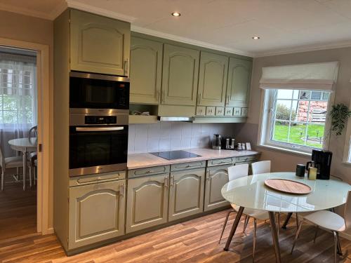 a kitchen with green cabinets and a table and a dining room at Magnhilds Luxury Apartment in Otta