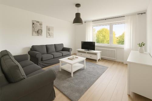 a living room with a couch and a tv at Penthouse Köln Pulheim 90 in Pulheim