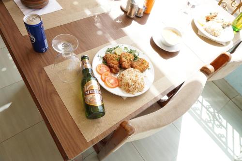 a table with a plate of food and a bottle of beer at Merry Land Hotel & Roof Top Nile Restaurant Luxor in Luxor
