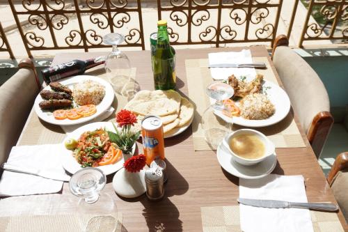 a wooden table with plates of food on it at Merry Land Hotel & Roof Top Nile Restaurant Luxor in Luxor