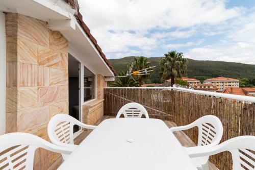 a white table and chairs on a balcony with a view at La Casita De La Pitufa in Vargas