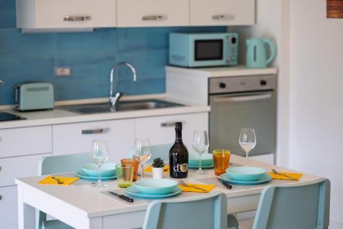 a kitchen with a table with a bottle of wine and glasses at Conca d'Oro Apartments, appartamento 5 e 6 in Arco