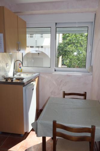 a small kitchen with a table and a window at Apartmani Mulic in Sutomore