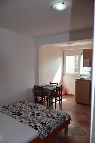 a room with a table and chairs and a kitchen at Apartmani Mulic in Sutomore
