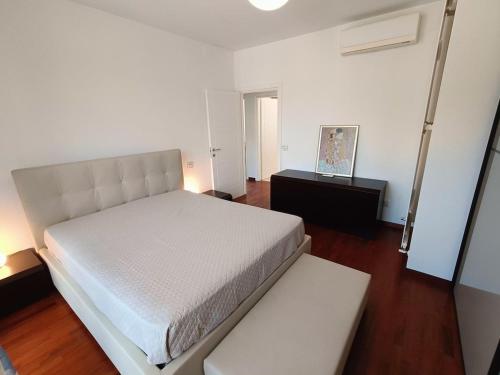 Un dormitorio con una cama blanca y una mesa. en Villetta elegantemente arredata, en Cervia