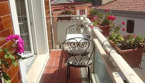 a chair sitting on a balcony with flowers at Appartamento Valkiria in Nuoro
