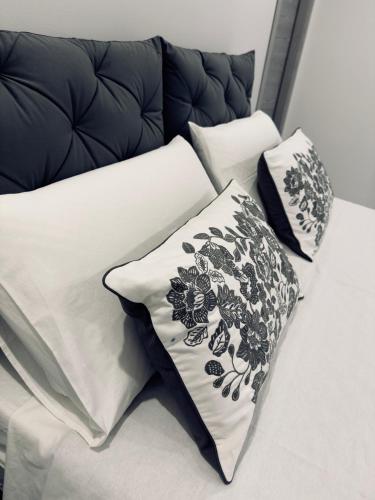 a bed with black and white pillows on it at DIAZ House Airport in CTA