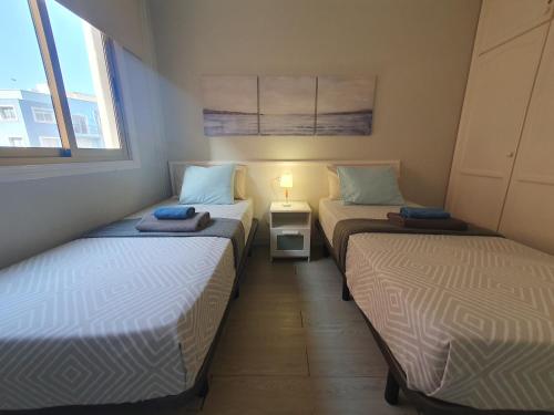 En eller flere senge i et værelse på Alquilaencanarias Medano Pika Mediterraneo