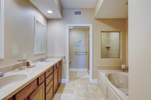 Un baño con dos lavabos y una bañera. en 403 Main Sail, en Hilton Head Island