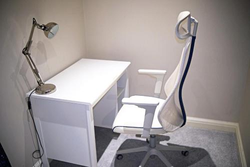 a white desk with a chair and a lamp at Thirlmere in Upholland