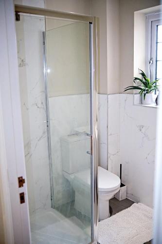 a bathroom with a toilet and a glass shower at Thirlmere in Upholland