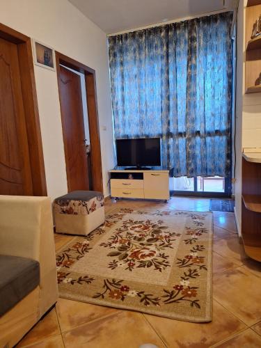 a living room with a couch and a tv at Summer apartment! in Durrës