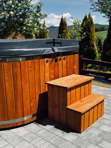 a wooden bar with a bench on a patio at Bieszczadzki Zakątek 787-899-185 in Bukowiec
