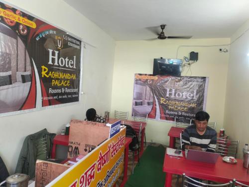 a man sitting at a table in a room with boxes at Raghunandan Palace in Phata