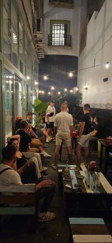 a group of people sitting and standing in a room at Play Hostel Arcos in Buenos Aires