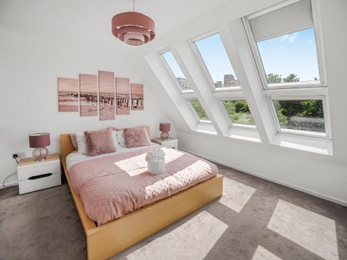 a bedroom with white walls and windows and a bed at Chic Riverside Retreat Salford 4bd free parking in Manchester