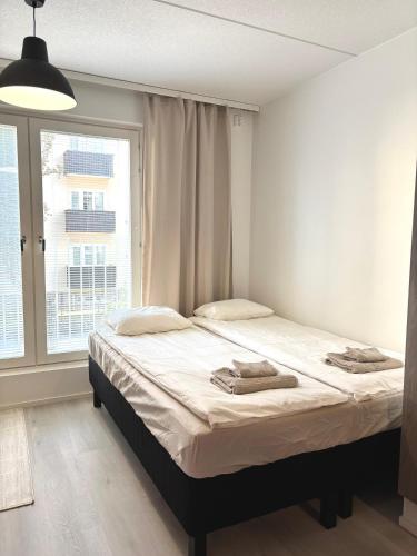 un lit dans une chambre avec une grande fenêtre dans l'établissement Foliate Living Nuppu, à Jyväskylä