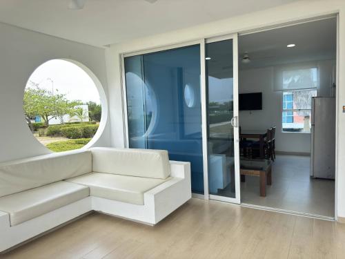 a living room with a white couch and a window at Marina Puerto Velero in Tubará