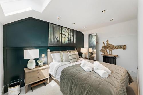 a bedroom with a large bed with a green wall at Gorgeous 3 Bedroom, 225 year old cottage in Portishead