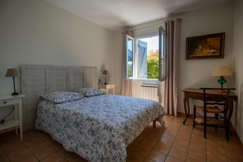 une chambre avec un lit, un bureau et une fenêtre dans l'établissement Belle maison jardin piscine près Avignon, à Villeneuve-lès-Avignon