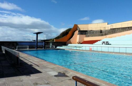 a large swimming pool in front of a building at Gorgeous 3 Bedroom, 225 year old cottage in Portishead