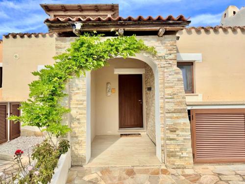 a house with an archway leading to a door at Villa with private swimming pool in Punta de Su Turrione in Cuile Pazzoni