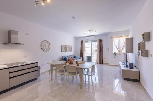 a kitchen and dining room with a table and chairs at Seaside Serenity 5 - few mins walk to the beach by QuickTrips in Is-Sellum