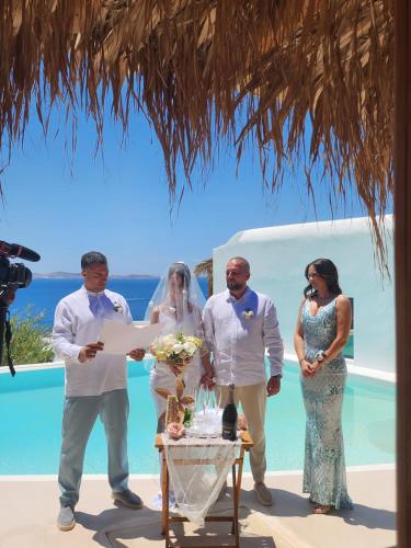 a bride and groom signing a certificate at their wedding ceremony at ELLI TROPiCAL LUXURY SUITES SUNSET-INFINITY POOL- SEA SIDE-NEAR CENTER PARKING in Mikonos