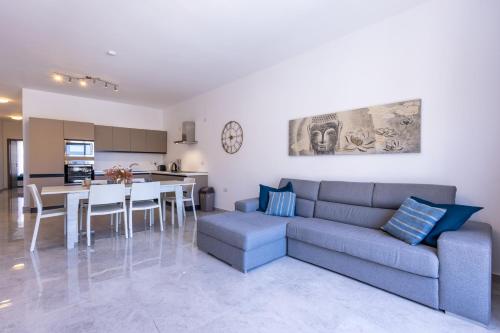a living room with a couch and a table at Seaside Serenity 5 - few mins walk to the beach by QuickTrips in Is-Sellum
