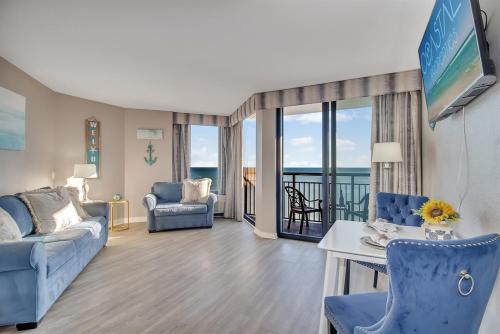a living room with blue furniture and a view of the ocean at Coastal Serenity 1Br Oceanfront Suite, Dogs OK! 1810 in Myrtle Beach