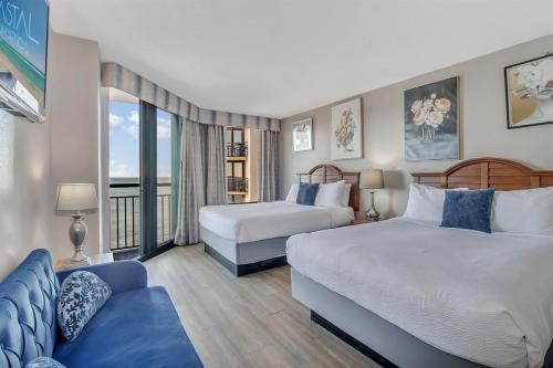 a hotel room with two beds and a couch at Coastal Serenity 1Br Oceanfront Suite, Dogs OK! 1810 in Myrtle Beach