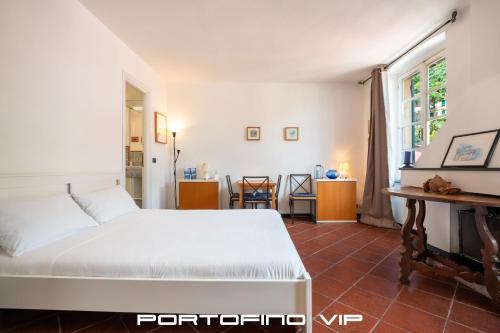 a bedroom with a white bed and a table at Acquamarina by PortofinoVip in Portofino