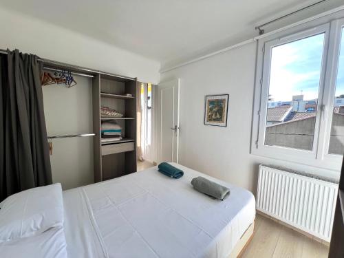 une chambre avec un lit blanc et une fenêtre dans l'établissement Casa Luz, à Montpellier