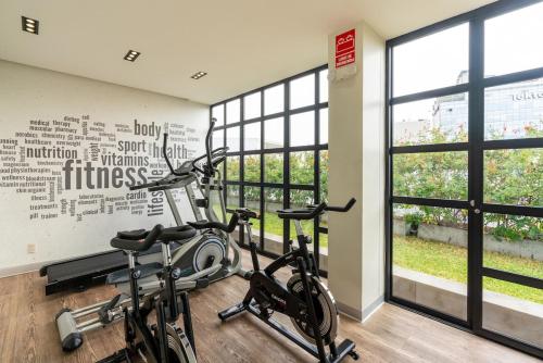 a gym with two bikes in a room with windows at Perricholi Central Apartments by Geko in Lima