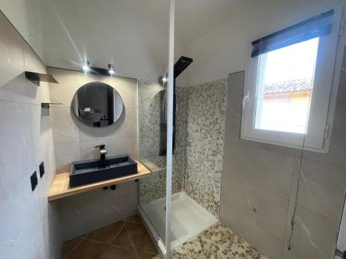 een badkamer met douche, wastafel en spiegel bij Villa Immortelle, Piscine, SPA, 500m plages et commerces in Lecci