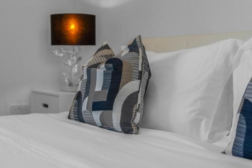 a bed with two pillows on top of it at Luxe 5 Bedroom Guardbridge House - St Andrews in St. Andrews