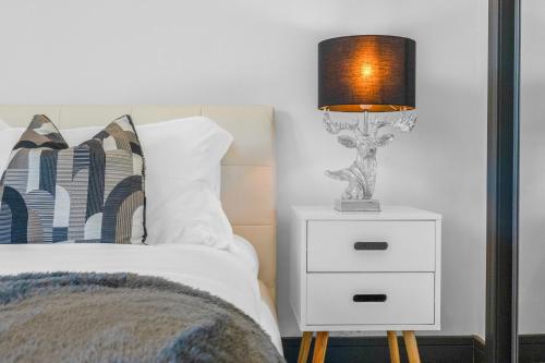 a lamp on a night stand next to a bed at Luxe 5 Bedroom Guardbridge House - St Andrews in St. Andrews