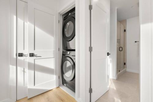 a white laundry room with two washer and dryer at Boston Skyline Stay 1BR with City Views in Boston