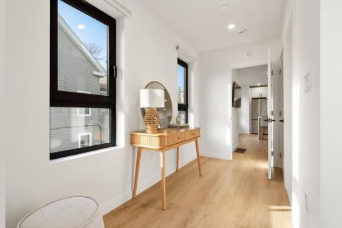 a hallway with a table with a lamp and a window at Boston Skyline Stay 1BR with City Views in Boston