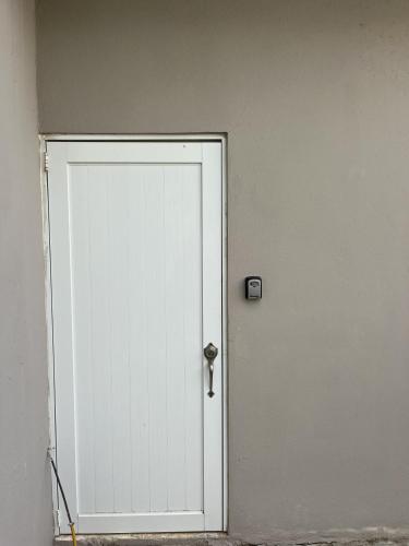 a white door with a key on a wall at Surfer Steps Apartment in Aguadilla
