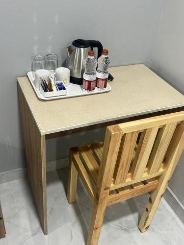 a table and a chair with a tray of food at Hotel Bhavans Elite in Rajiv Gandhi International Airport