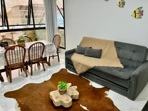 a living room with a couch and a table at Apto Vida Boa 2 - 250m do mar in Palhoça